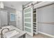 Modern bathroom featuring a double sink vanity, glass shower, and unique sliding door to the closet at 1702 Falls Church Rd, Raleigh, NC 27609