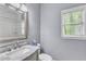 Well-lit bathroom with white subway tile shower, marble countertop vanity, and window at 1702 Falls Church Rd, Raleigh, NC 27609