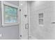 Shower featuring white subway tile, hexagon tile floor, a built-in niche, and natural light from a window at 1702 Falls Church Rd, Raleigh, NC 27609