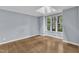 Well-lit bedroom with hardwood floors, skylight, and large windows offering lots of natural light at 1702 Falls Church Rd, Raleigh, NC 27609