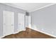 Empty bedroom featuring hardwood floors and three doors at 1702 Falls Church Rd, Raleigh, NC 27609