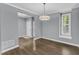 Neutral dining room featuring an updated light fixture, hardwood flooring and large windows at 1702 Falls Church Rd, Raleigh, NC 27609