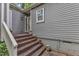 Welcoming entrance featuring brick steps, elegant plants, and gray siding at 1702 Falls Church Rd, Raleigh, NC 27609