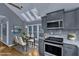 Bright eat-in kitchen with stainless appliances, gray cabinets, and skylights over the dining area at 1702 Falls Church Rd, Raleigh, NC 27609