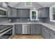 Stylish kitchen features gray cabinets, stainless steel appliances, and granite countertops at 1702 Falls Church Rd, Raleigh, NC 27609