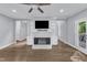 Open-concept living room featuring a fireplace, built-in bookshelves, hardwood floors, and lots of natural light at 1702 Falls Church Rd, Raleigh, NC 27609