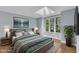Elegantly staged bedroom with a large bed, scenic window view, and a modern artistic touch at 1702 Falls Church Rd, Raleigh, NC 27609