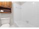 Bright bathroom featuring a tiled shower/bathtub combination and a wood storage cabinet at 1724 Briarforest Pl, Raleigh, NC 27615