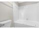 Bright bathroom features a white tiled shower/tub combo and white toilet at 1724 Briarforest Pl, Raleigh, NC 27615