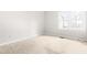 A sunlit bedroom featuring neutral walls, plush carpeting, and a bright window at 1724 Briarforest Pl, Raleigh, NC 27615