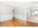 Dining room with hardwood floors and chandelier, offering views into other rooms at 1724 Briarforest Pl, Raleigh, NC 27615