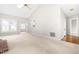 Bright living room featuring vaulted ceilings, skylight, fireplace, and neutral carpeting at 1724 Briarforest Pl, Raleigh, NC 27615