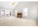 Spacious living room featuring vaulted ceilings, skylight, fireplace, and neutral carpeting at 1724 Briarforest Pl, Raleigh, NC 27615