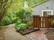 Charming home courtyard featuring brick accents, a privacy fence, and lush green landscaping at 173 Clancy Cir, Cary, NC 27511