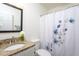 Bathroom with a granite countertop, a large mirror, and a shower with floral shower curtain at 175 Fox Run Rd, Youngsville, NC 27596