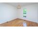 Empty bedroom with hardwood floors, white walls, a window and a wicker light fixture at 175 Fox Run Rd, Youngsville, NC 27596