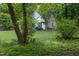 View of a home from the yard that is surrounded by dense trees at 175 Fox Run Rd, Youngsville, NC 27596