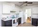 Traditional kitchen with white appliances, white cabinets, black lower cabinets and a ceiling fan at 175 Fox Run Rd, Youngsville, NC 27596