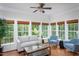 Bright living room with hardwood floors, many windows, with neutral colored furniture and a ceiling fan at 175 Fox Run Rd, Youngsville, NC 27596