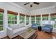 Bright living room with hardwood floors, many windows, with neutral colored furniture and a ceiling fan at 175 Fox Run Rd, Youngsville, NC 27596