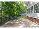 Rear of home featuring back deck with table set, fenced backyard, storage shed and lush landscaping at 175 Fox Run Rd, Youngsville, NC 27596