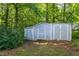 View of a grey wooden shed sitting amongst the trees at 175 Fox Run Rd, Youngsville, NC 27596