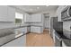 Open kitchen with stainless steel appliances, granite countertops, and bright, white cabinets at 188 Karlov Rd, Garner, NC 27529