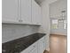 Bright kitchen featuring white cabinets, dark granite countertops, and subway tile backsplash at 188 Karlov Rd, Garner, NC 27529
