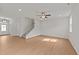 Spacious open-concept living room with wood floors, staircase and ceiling fan with light at 188 Karlov Rd, Garner, NC 27529