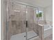 Updated tiled shower and tub with glass door and window for natural light, creating a spa-like experience at 188 Karlov Rd, Garner, NC 27529