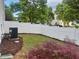 View of the backyard showcasing a white fence, grass, and decorative plants at 1924 Barngate Way, Raleigh, NC 27614