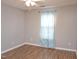 Bedroom with wood flooring and a window covered by an aqua-patterned curtain at 1924 Barngate Way, Raleigh, NC 27614