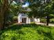 Two-story home with a small front balcony, landscaped with mature trees and shrubbery at 201 Cooke St, Raleigh, NC 27601
