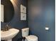 Stylish powder room featuring a pedestal sink, round mirror, and tasteful decor at 201 Cooke St, Raleigh, NC 27601