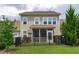 Rear view of home with fenced in porch and well-maintained lawn and landscaping at 210 Mayfield Dr, Apex, NC 27539