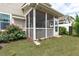 The backyard has green grass surrounding a screened in back porch and manicured rose bushes at 210 Mayfield Dr, Apex, NC 27539