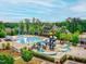 Aerial view of community pool area including a large pool, playground, kiddie pool, and community clubhouse at 210 Mayfield Dr, Apex, NC 27539
