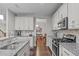 Bright kitchen with granite counters, stainless steel appliances and white cabinets flowing into the dining area at 210 Mayfield Dr, Apex, NC 27539