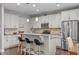 Eat-in kitchen area features white cabinets, stainless steel appliances, a breakfast bar and granite countertops at 210 Mayfield Dr, Apex, NC 27539