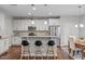 Bright kitchen with white cabinets, a breakfast bar with seating, granite counters and stainless steel appliances at 210 Mayfield Dr, Apex, NC 27539