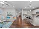 Open-concept living room featuring hardwood floors, a kitchen bar, and comfortable seating at 210 Mayfield Dr, Apex, NC 27539