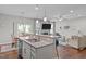 Open floor plan from kitchen to living room with island seating and stainless steel appliances at 210 Mayfield Dr, Apex, NC 27539