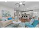 Bright living room with hardwood floors, a ceiling fan, and an open floor plan flowing into the kitchen at 210 Mayfield Dr, Apex, NC 27539