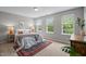 Bright bedroom featuring three windows, a patterned rug, and neutral walls at 214 Cedar Elm Rd, Durham, NC 27713
