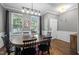 Inviting dining room featuring wood floors, gray walls, large windows, and modern lighting, perfect for Gathering gatherings at 214 Cedar Elm Rd, Durham, NC 27713