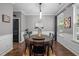Beautiful dining room with wood floors, modern light fixture, wainscoting, and a large window at 214 Cedar Elm Rd, Durham, NC 27713
