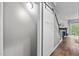 Hallway with sliding barn door, adjacent to staircase and fireplace at 214 Cedar Elm Rd, Durham, NC 27713