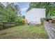 A fenced backyard featuring a small patio area with chairs, a grill, and a view of the home's exterior at 2216 Lawrence Dr, Raleigh, NC 27603