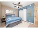 Bright bedroom featuring a modern ceiling fan, blue accent wall, and ample closet space at 2216 Lawrence Dr, Raleigh, NC 27603