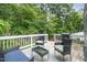 This is a wooden deck featuring outdoor furniture and a grill, surrounded by lush greenery at 2216 Lawrence Dr, Raleigh, NC 27603